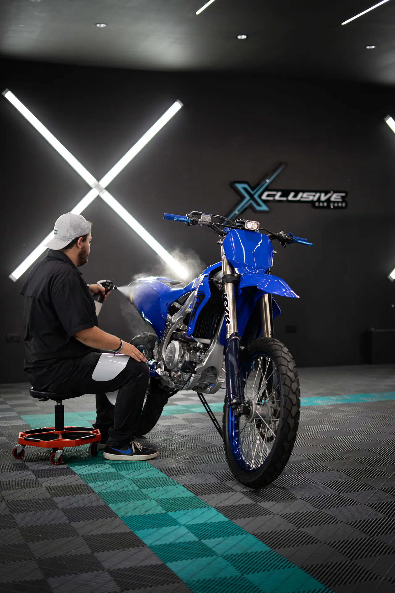 Técnico de Xclusive Bike Care trabajando en una moto enduro azul