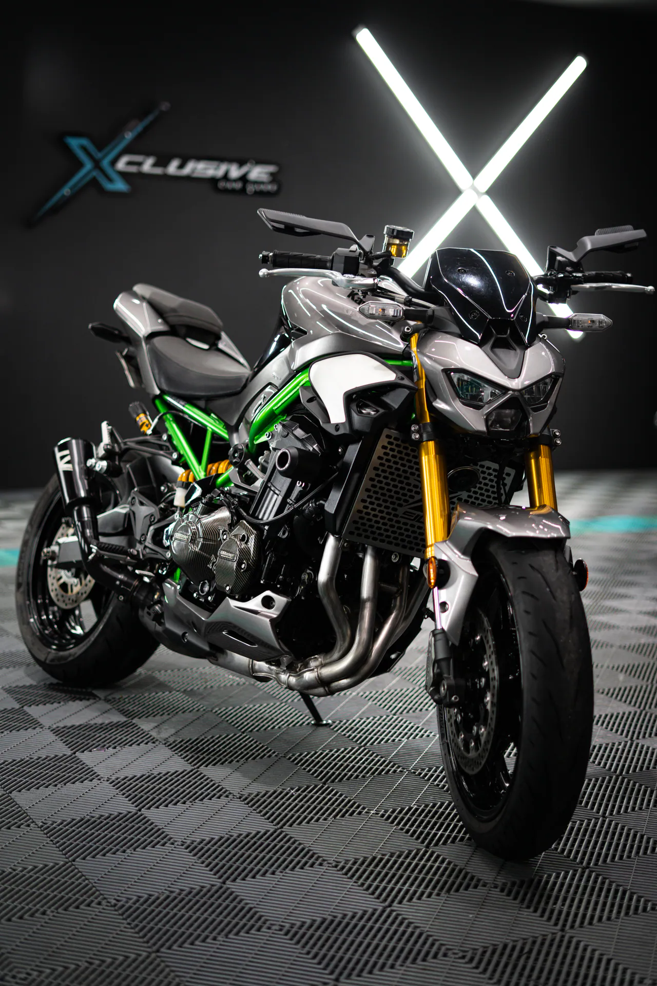 Motocicleta naked de marco verde bajo las luces del estudio