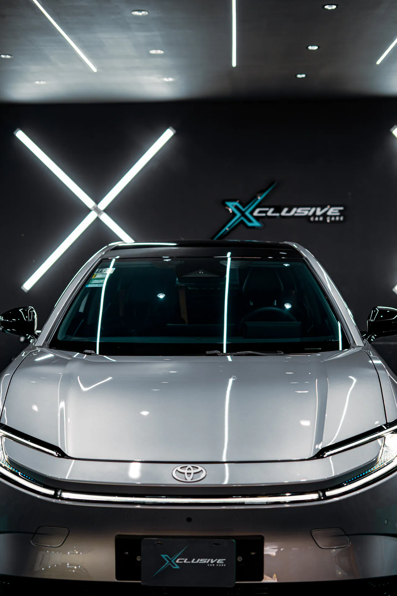 Toyota con polarizado LUNARAY frente al logo de Xclusive en el estudio