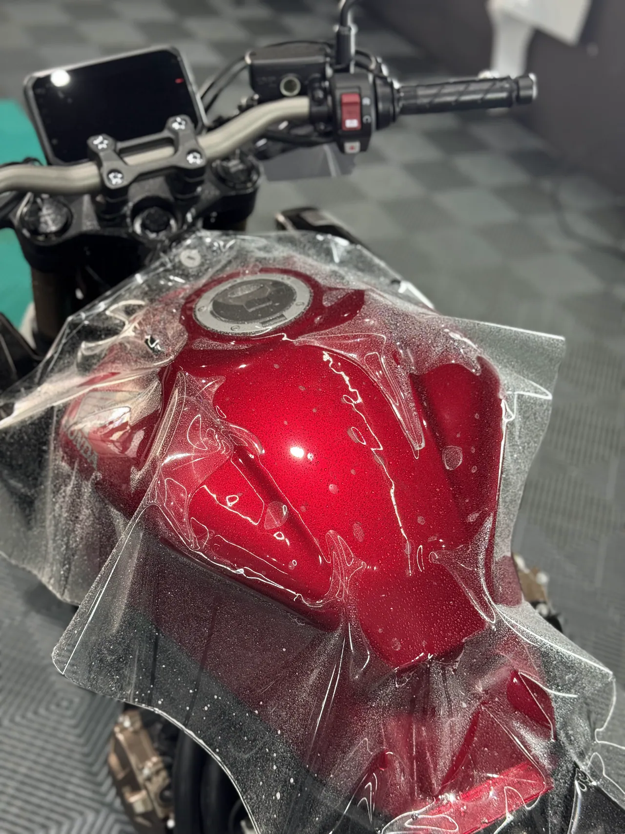 Tanque rojo de una motocicleta durante la instalación de PPF